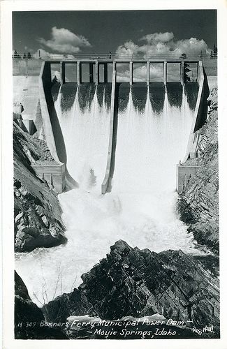 An old photo of water falling down the front of a dam.